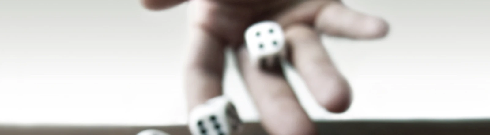 A hand throwing two dice