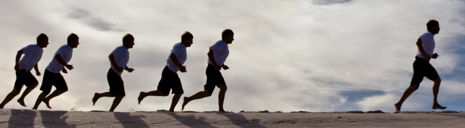 People running in a single file on sand