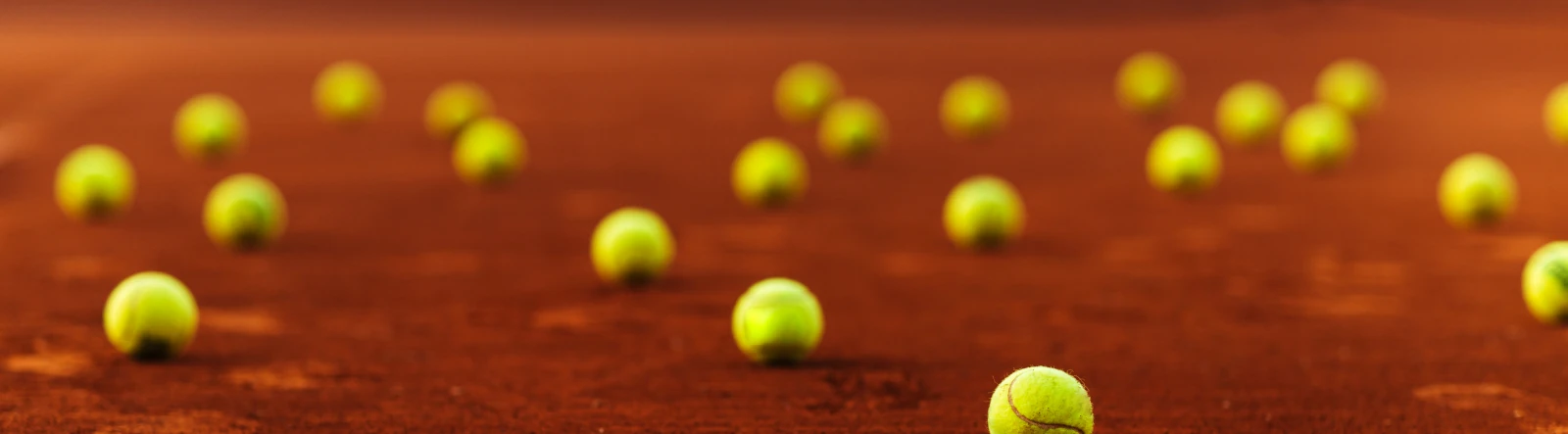 Several tennis balls laid out on a running track